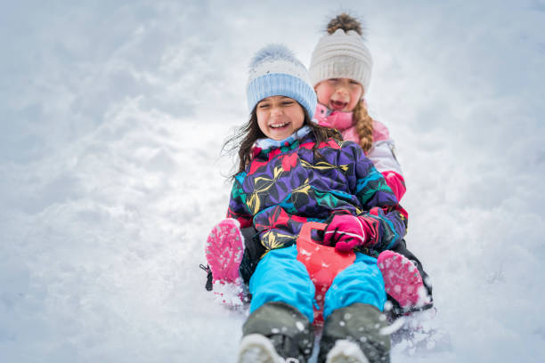 istock Girls sliding on snow 1147315466