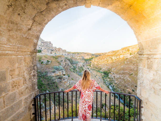 Young blonde girl looking out over the  landscape of the Sassi di Matera Young blonde girl looking out over the  landscape of the Sassi di Matera, prehistoric historic center, UNESCO World Heritage Site, European Capital of Culture 2019 (wide) murge photos stock pictures, royalty-free photos & images