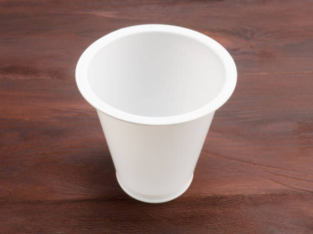 istock Plastic white glass on a brown wooden background 1147318168