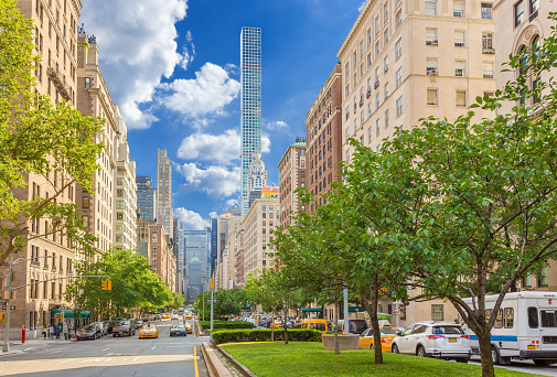 Park Avenue, Manhattan Upper East Side, New York City. Image shows 432 Park Avenue Luxury Condominium Tower, street, sidewalk, cars, green grass and trees and blue sky with clouds. Canon EOS 6D (Full Frame censor) and Canon EF 24-105mm f/4L IS lens. Circular polarizer.  HDR photorealistic image.
