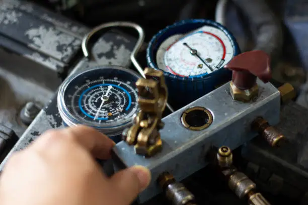 Photo of Auto mechanic worker fixing air condition in car garage .
Monitoring tools check car air conditioner system.â¨Vehicle engine maintenanceÂ service, Repair Engine pressure measurement system.