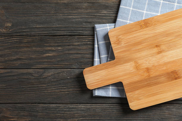 istock Cutting board with kitchen towel on wooden background, space for text 1147321346