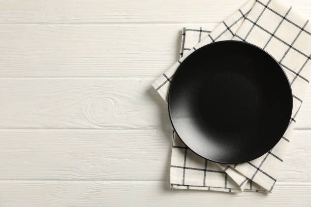 istock Kitchen towel with plate on wooden background, top view 1147321423
