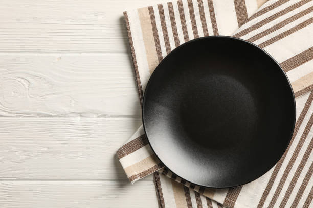 istock Kitchen towel with plate on wooden background, top view 1147321474