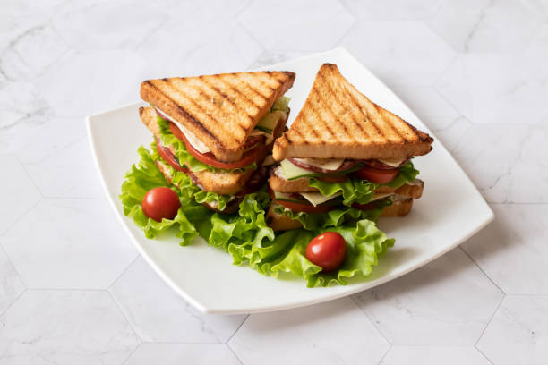 istock Sandwich with cheese, tomato, cucumber, sausage and salad on a light background. . Horizontal orientation 1147321498