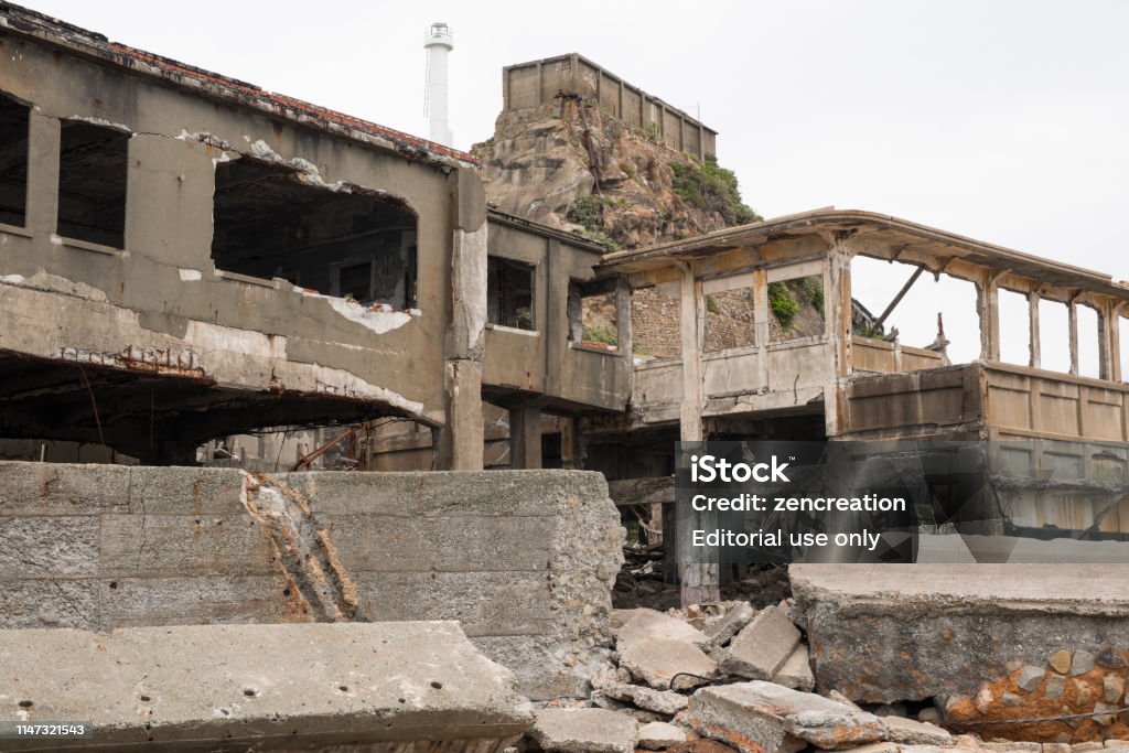 Ruins in Hashima Island, Japan Hashima Island, Japan - 11 April 2019: Hashima Island-Gunkanjima meaning Battleship Island, is an abandoned island lying about 15 kilometers (9 miles) from the city of Nagasaki, in southern Japan. This is former coal mining island. It is old coal mine in Japan closed at 1974 due to the closure of coal mine. Hashima Island Stock Photo