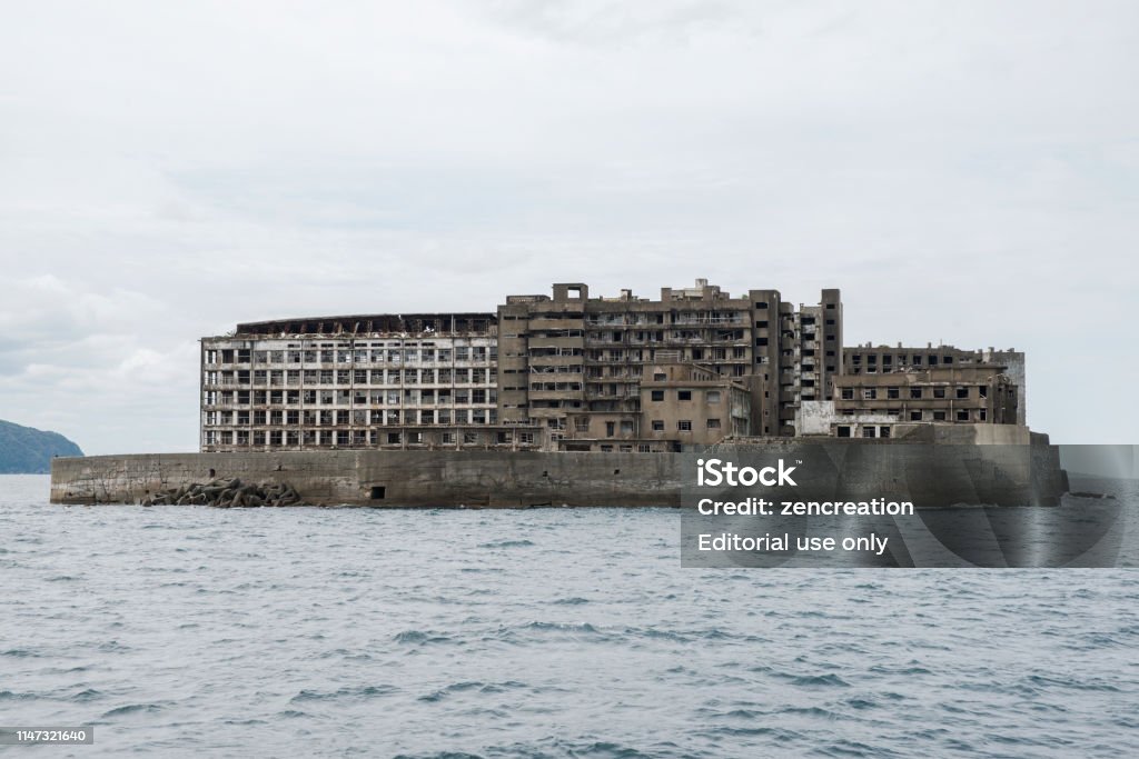 Ruins in Hashima Island, Japan Hashima Island, Japan - 11 April 2019: Hashima Island-Gunkanjima meaning Battleship Island, is an abandoned island lying about 15 kilometers (9 miles) from the city of Nagasaki, in southern Japan. This is former coal mining island. It is old coal mine in Japan closed at 1974 due to the closure of coal mine. Hashima Island Stock Photo