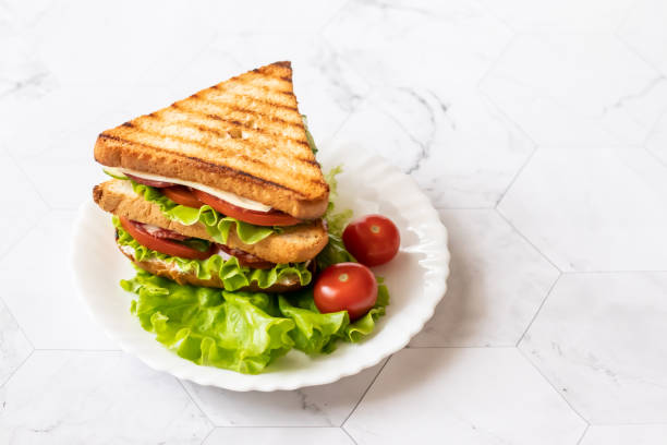 istock Sandwich with cheese, tomato, cucumber, sausage and salad on a light background. . Horizontal orientation 1147321930