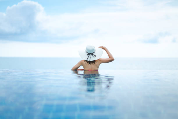 istock Asian woman relax in pool on beach 1147327210