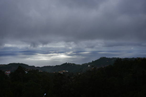 istock Shafts of sunlight slicing through the heavy rain clouds light up sparkling patterns on the sea in Maderia 1147328507