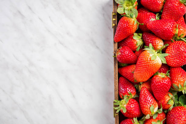 istock Strawberries in wooden box, border marble background 1147337458