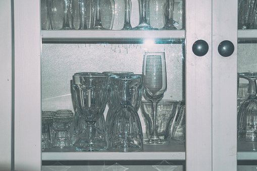 Clean empty wine glasses on the shelf in the cupboard. Soft focus