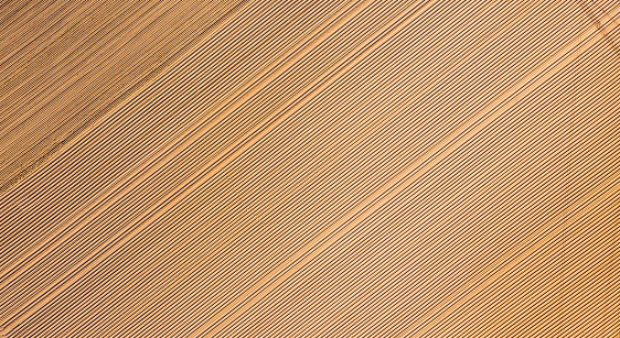 Aerial view, Rows of soil before planting,row pattern in a plowed field  in spring.Horizontal view in perspective