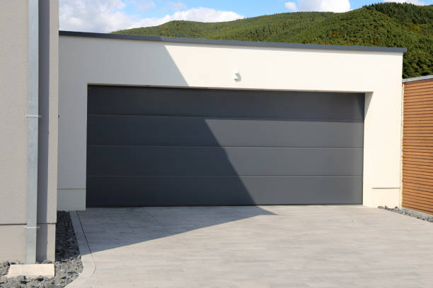 istock New black garage door (sectional door) with mountains and forest in the background 1147340556