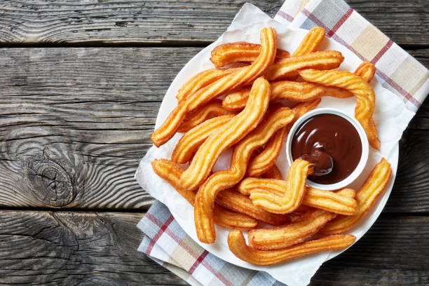 istock delicious churros with chocolate dipping  on a white plate on a wooden table 1147340865