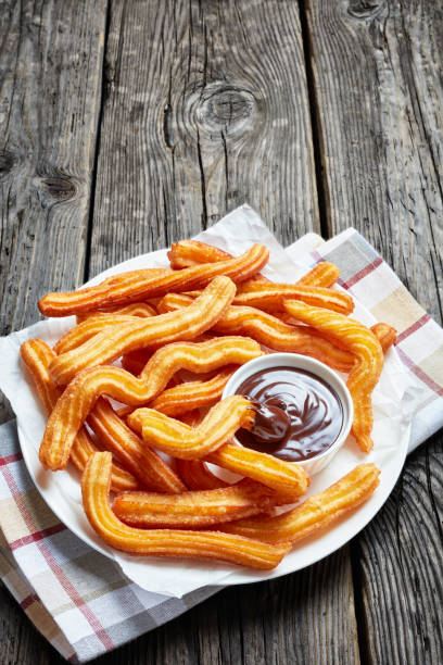 istock delicious churros with chocolate dipping  on a white plate on a wooden table 1147340897