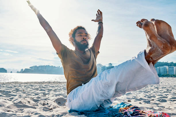 istock man doing yoga on the beach 1147344654