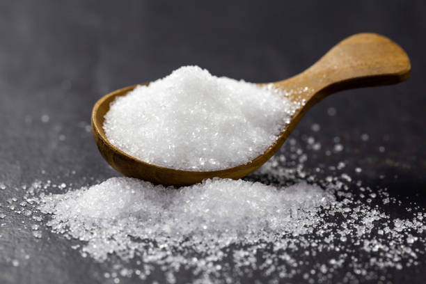 istock Sugar on a wooden spoon On a black background 1147346492
