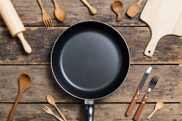 istock Cooking background,Top View of a Pan and different kitchenware On Old Wood Background 1147347023