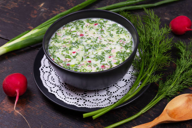 ロシアの夏の冷たいスープは、緑、野菜、クワスから okroshka、黒の木製のテーブルでケフィア - soup cold russian culture traditional culture ストックフォトと画像