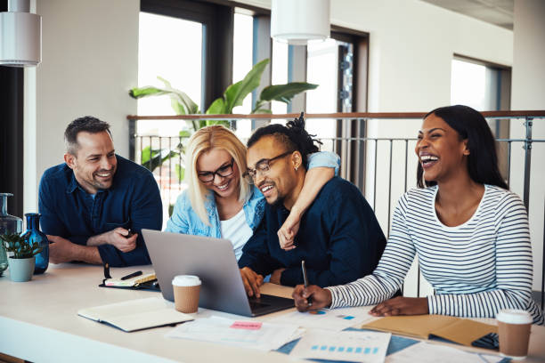 istock Laughing work colleagues sitting together during an office meeting 1147347654