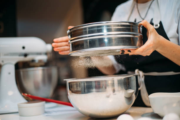 istock Woman hands sieving flour 1147348417
