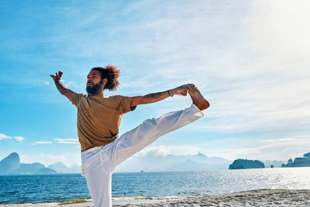 istock man doing yoga on the beach 1147348511