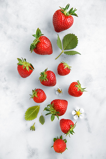Strawberries on a a marble background viewed from above. Top view