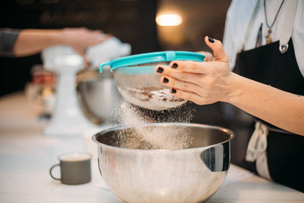 istock Woman hands sieving flour 1147348766