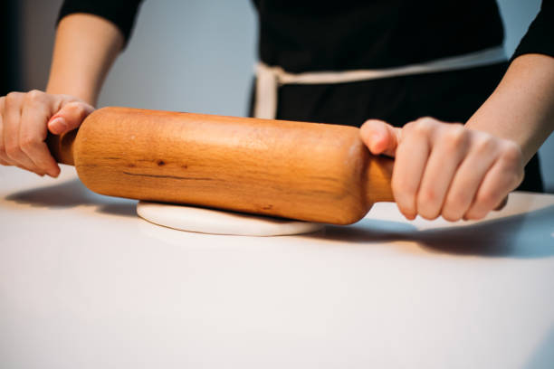 Close up of female baker hands kneading dough
