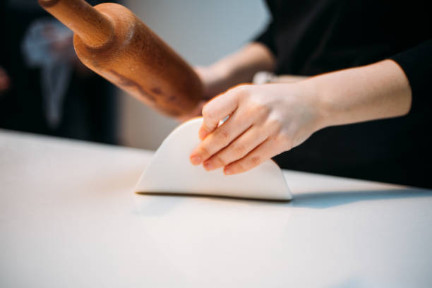 istock Close up of female baker hands kneading dough 1147349049