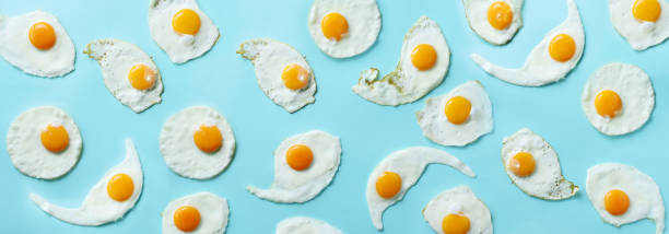 istock Fried eggs or scrambled eggs pattern on blue background. Creative food concept. Top view. Banner 1147349837