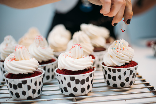 Woman hand decorating cupcakes
