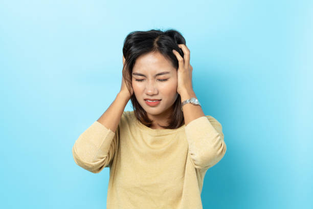 istock asian young woman having headache on white background 1147350880