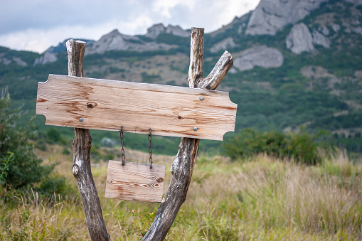 Empty wooden direction pointer in mountains with place for text.