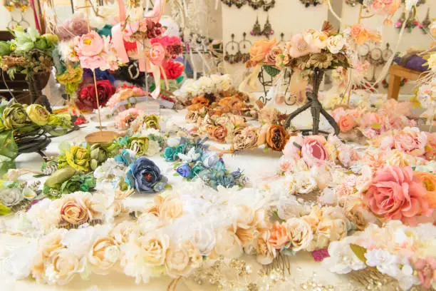 Various colorful artificial flowers, handmade by artisan and exposed in medieval market