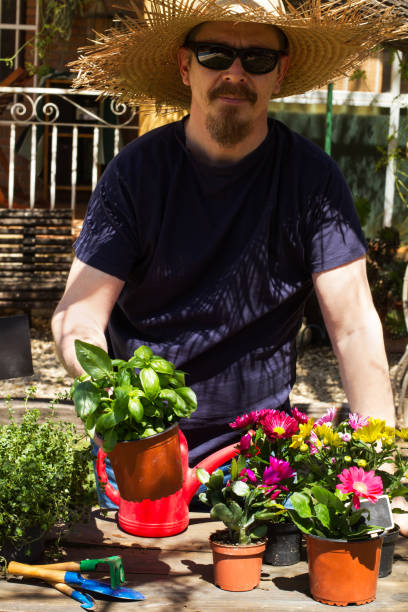Man with flower pots on a wooden table