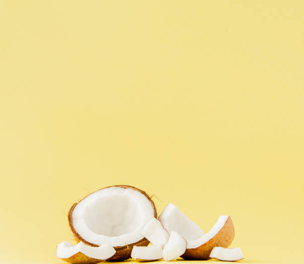istock close up fresh coconut pieces isolated on a yellow background, tropical fruit concept, flat lay, pop art, copy space 1147362493