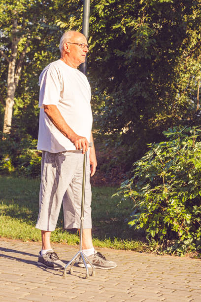 istock Close up hands of old man with his walking stick 1147364999