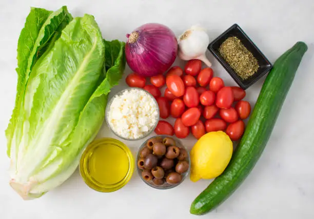 Fruits, vegetables, and seasonings to make Greek salad and salad dressing