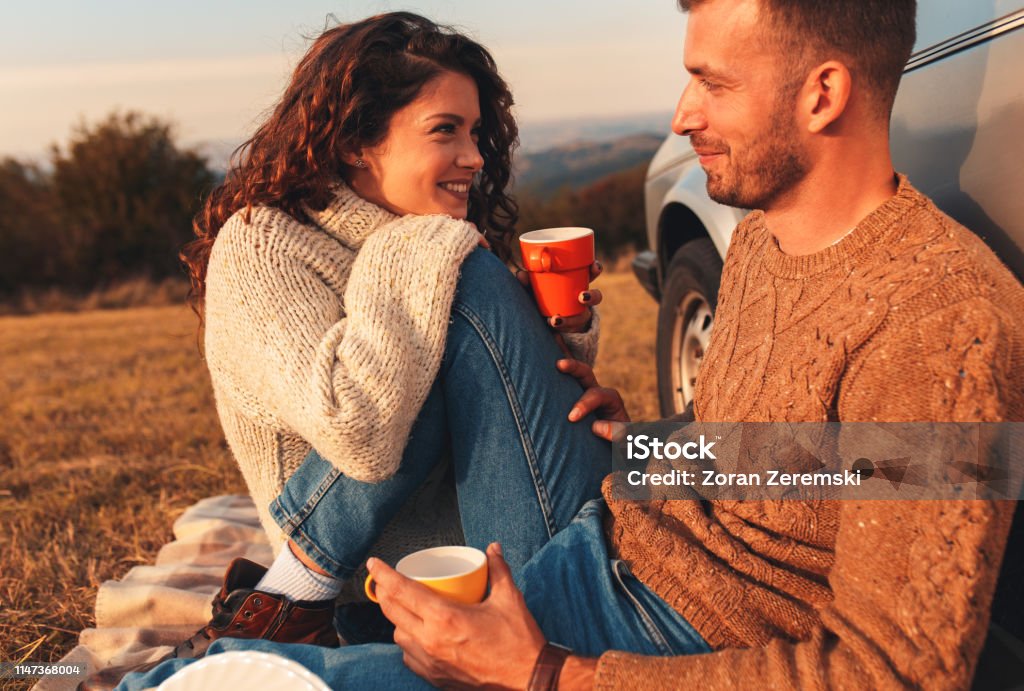 아름 다운 젊은 부부는 석양에 피크닉 시간을 즐기는. - 로열티 프리 데이트 스톡 사진
