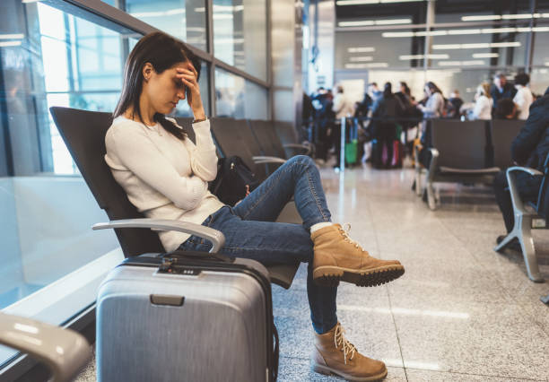 Exhausted passenger at the airport Young woman napping at the airport departure area while waiting for the flight delayed sign photos stock pictures, royalty-free photos & images