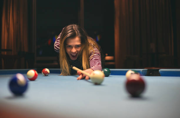 istock cute young woman aiming white pool ball 1147368721