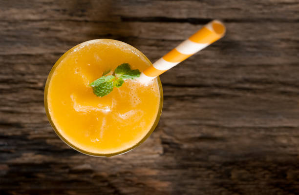 istock Mango smoothies  juice and fruit mango drink in a glass drink orange colorful fruit juice milkshake blend beverage healthy high protein the taste yummy in glass on wood background from the top view. 1147369501