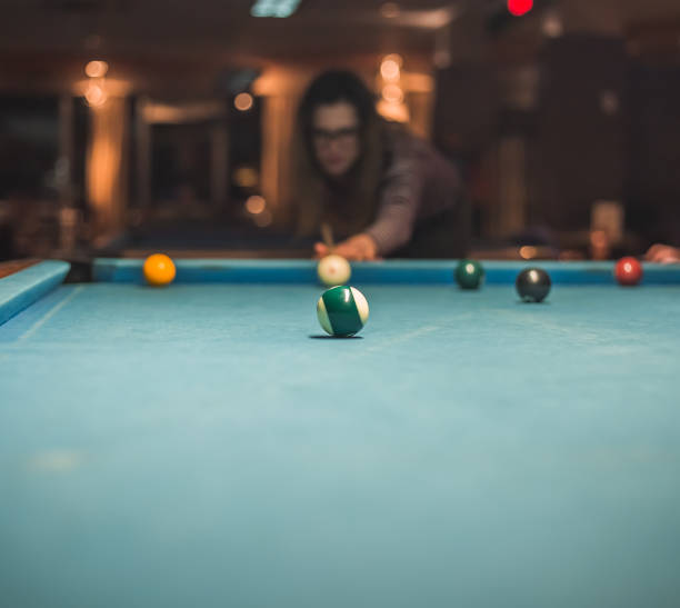 istock Woman going hit a ball with cue in billiard 1147369592