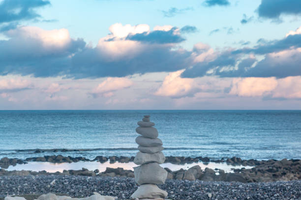 A pile of zen rocks on a pebble beach in Sussex, with the ocean behind and an evening sky overhead