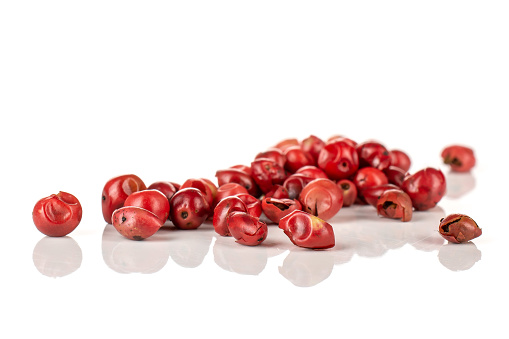 Closeup of lot of whole peruvian pink pepper isolated on white background