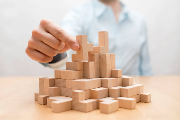 Man's hand stacking wooden blocks. Business development concept stock photo