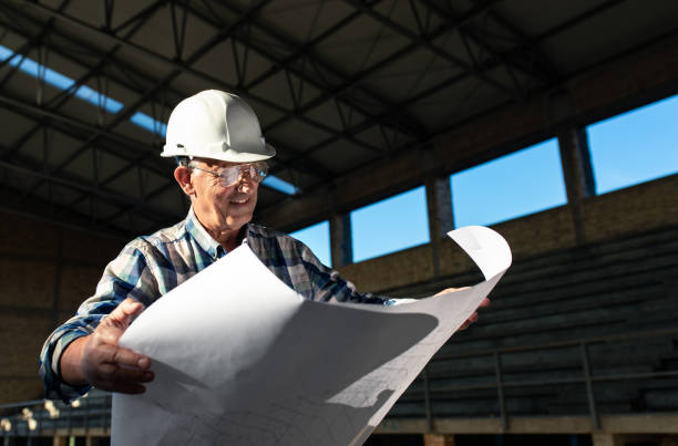 istock Senior construction manager with blueprint controlling building site. 1147373057