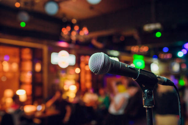 istock modern microphone for singing against beautiful blurry colored bokeh. 1147373967